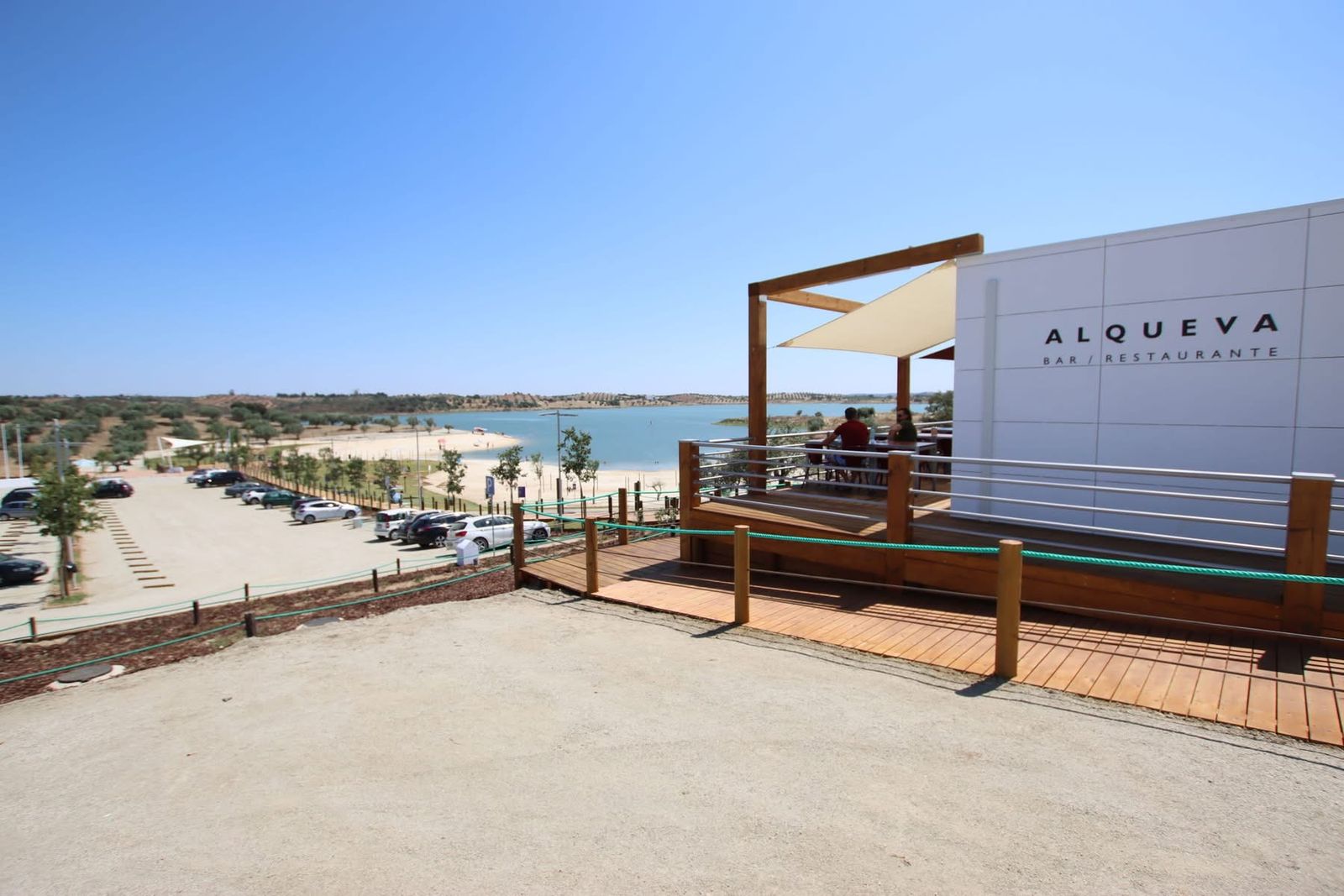 Praia fluvial do Alqueva, com areal, bar e o lago em fundo