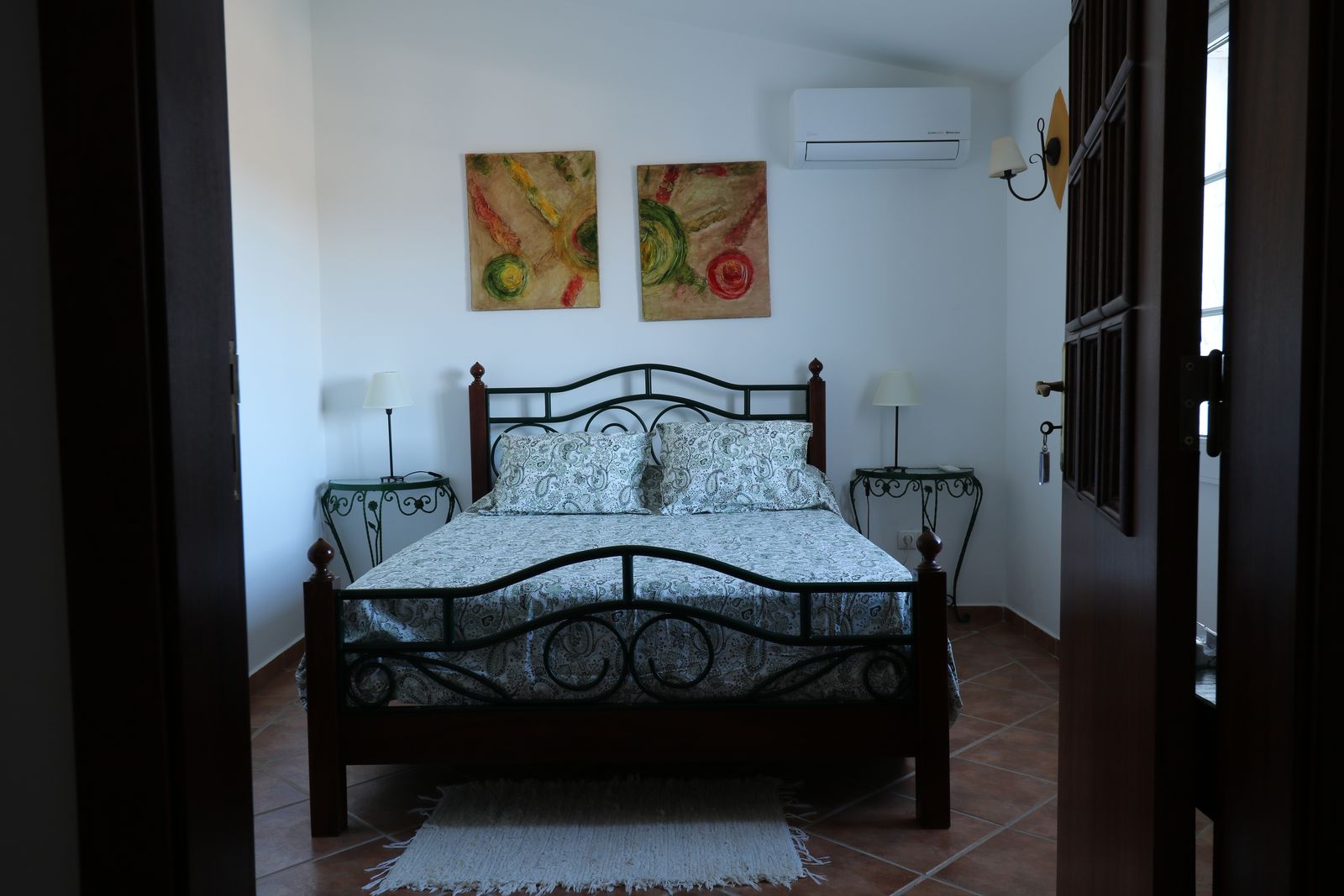 Quarto Verde, com cama de casal em ferro forjado e ar condicionado