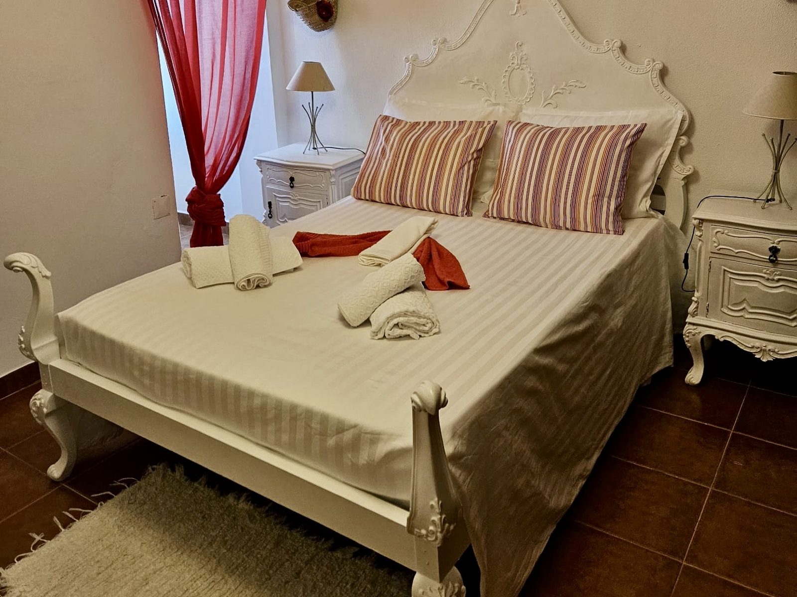 Quarto Vermelho, com cama de casal e máquina de costura antiga